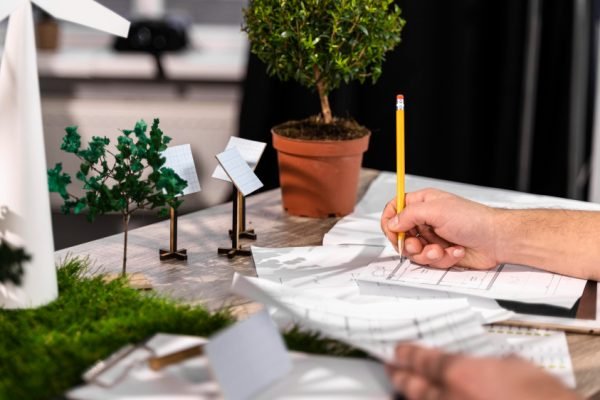 side-view-man-working-eco-friendly-wind-power-project-with-paper-plans side-view-man-working-eco-friendly-wind-power-project-with-paper-plans